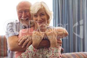 Happy senior couple sitting on sofa at retirement home