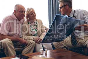 Male doctor discussing over x ray with senior couple