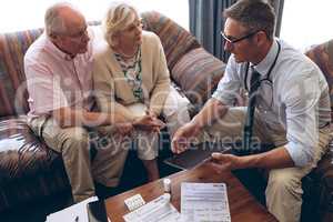 Doctor and couple discussing over digital tablet