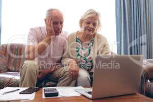 Couple looking medical report on laptop at retirement home