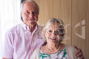 Happy senior couple standing at retirement home