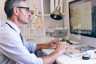 Male doctor working on computer at clinic of retirement home