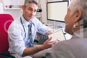 Male doctor and senior woman interacting with each other