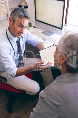 Male doctor and senior woman interacting with each other