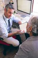 Male doctor and senior woman interacting with each other