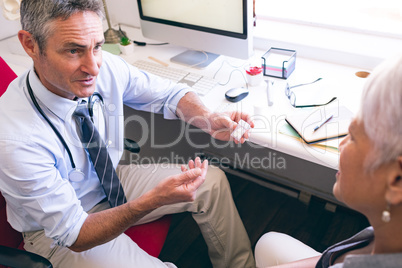Male doctor prescribing medicine to senior woman