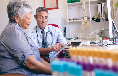 Male doctor showing medical report to the senior female patient