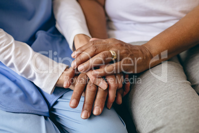 Female doctor holding hand of senior patient