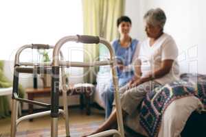 Female doctor interacting with senior female patient at retirement home
