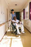 Nurse standing while male sits in wheelchair