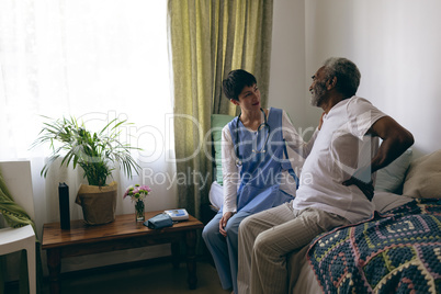 Female doctor and senior male patient interacting with each other