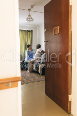 Female doctor and senior male patient interacting with each other