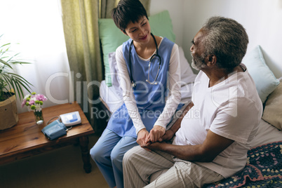 Female doctor and senior male patient interacting with each other