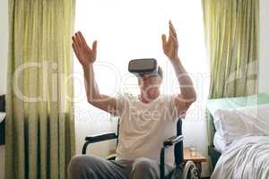 Senior male patient using virtual reality headset at retirement home