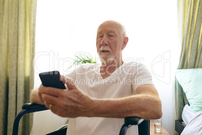 Senior male patient using mobile phone at retirement home