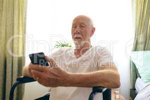 Senior male patient using mobile phone at retirement home