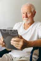 Senior male patient using digital tablet at retirement home