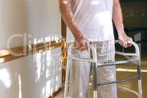 Senior male patient standing with walker