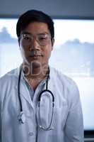 Smart male doctor standing in clinic at hospital