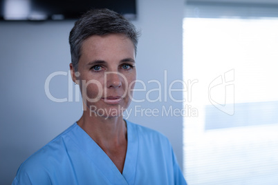 Female matured surgeon standing in clinic at hospital