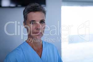 Female matured surgeon standing in clinic at hospital