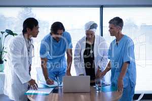Doctors discussing over laptop in clinic at hospital