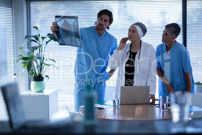 Surgeons looking and discussing over x-ray in clinic at hospital