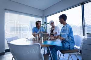 Doctor and surgeon discussing over laptop in clinic at hospital