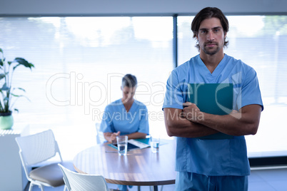 Confident male surgeon standing in clinic at hospital