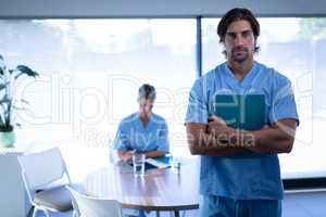 Confident male surgeon standing in clinic at hospital