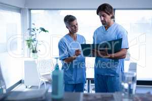 Surgeons discussing over medical file in clinic at hospital