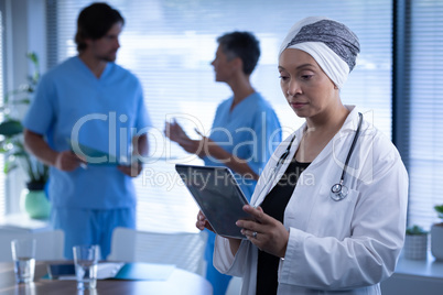 Female doctor looking at digital tablet in clinic at hospital