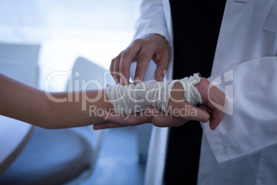 Matured female doctor examining girl hand in clinic