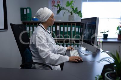 Matured female doctor working on computer in clinic at hospital