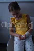 Girl sitting with fractured hand in clinic at hospital
