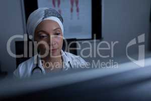 Matured female doctor working on computer in clinic at hospital