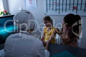 Matured female doctor examining girl hand in clinic