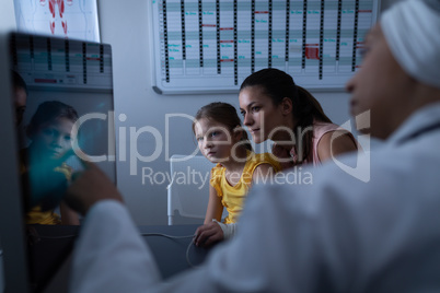 Matured female doctor showing medical report to patient