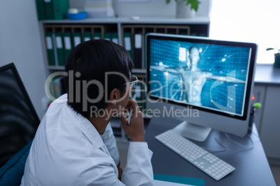 Confident male doctor looking on computer