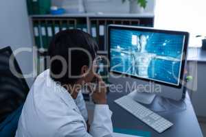 Confident male doctor looking on computer