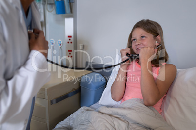 Girl patient listening to doctors heart beat with stethoscope