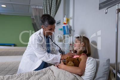 Doctor examining girl patient in clinic at hospital