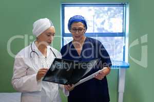 Doctors discussing over medical report in clinic at hospital