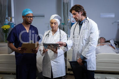 Doctors discussing over digital tablet in clinic at hospital