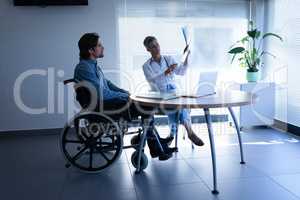 Mature female doctor and patient discussing over x-ray