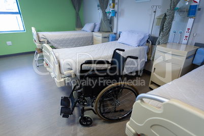 Row of empty hospital beds and wheelchair