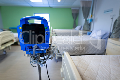 Sphygmomanometer machine with empty beds in hospital ward