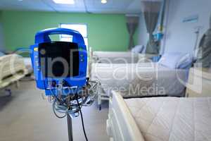 Sphygmomanometer machine with empty beds in hospital ward