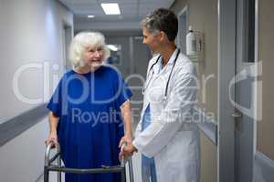 Mature female doctor talking with senior female patient in clinic at hospital