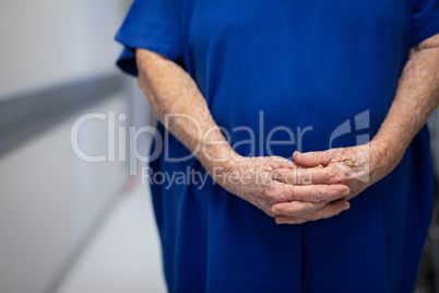 Senior female patient standing in hospital clinic